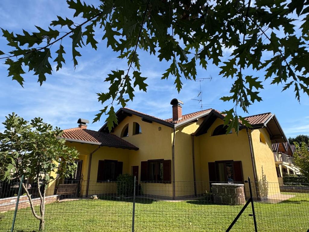 a yellow house with a fence in front of it at AirSisters Home in Ferno