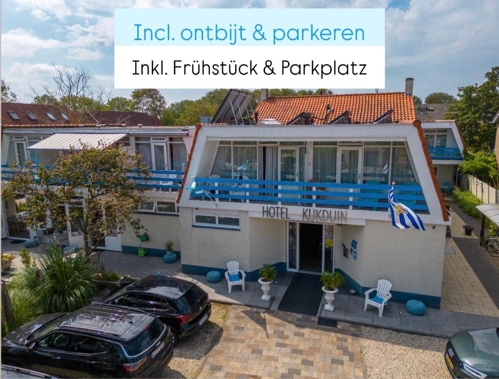 a house with a car parked in front of it at Hotel Kijkduin in Domburg