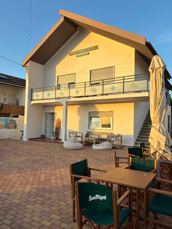 a house with a patio with tables and chairs at Hospedium República Surf House - Coxos Beach, Ericeira in Ericeira