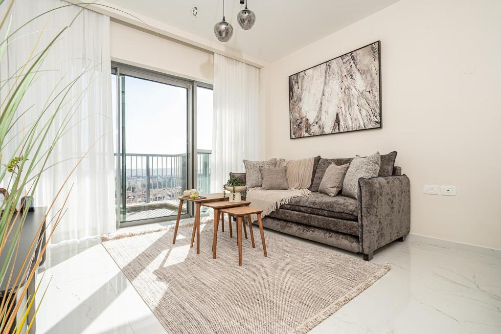 a living room with a couch and a table at Savyon View Tower - Isrentals in Jerusalem
