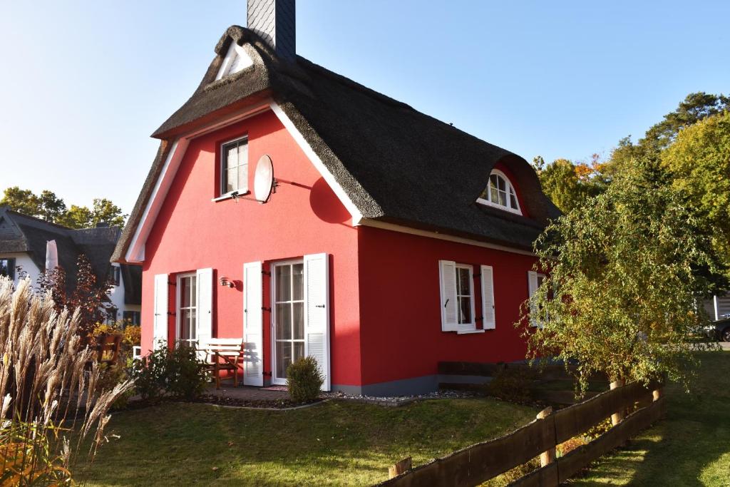 a red house with a black roof at Boddenkieker in Born