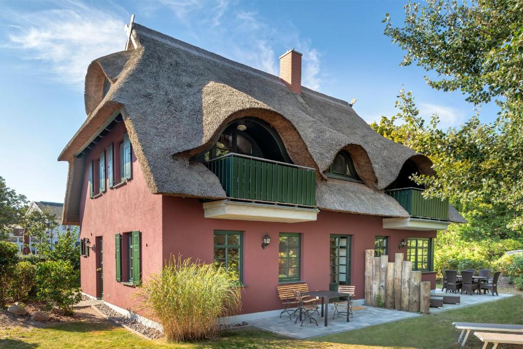 a house with a thatched roof with a patio at Strandhaus Ahrensh 2 in Ahrenshoop