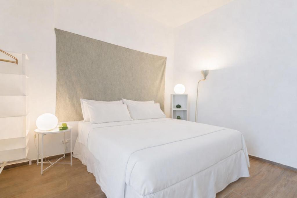 a white bedroom with a large white bed with white pillows at Sunny Vibes Monopoli in Monopoli