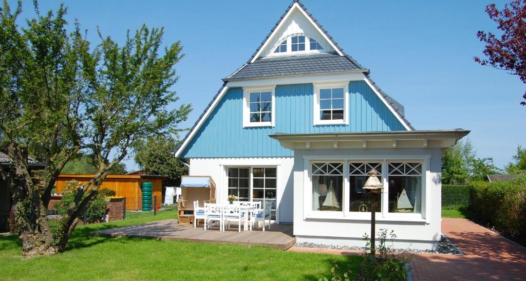 a blue and white house with a patio at Min Droom in Wustrow