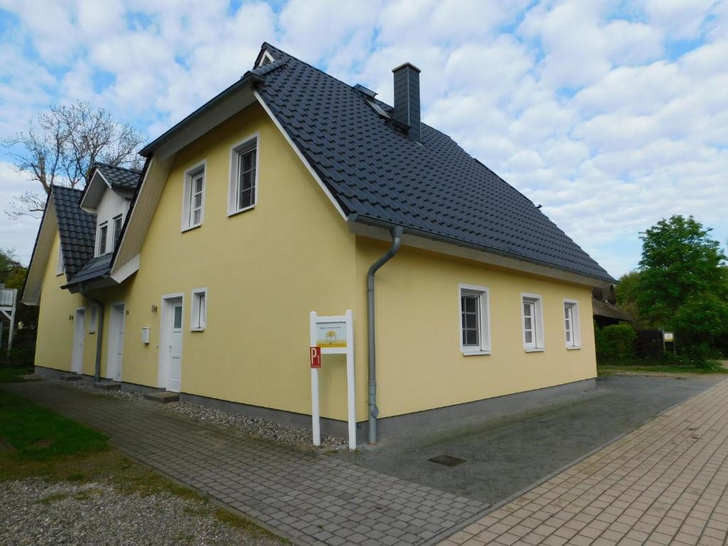 a yellow house with a black roof at Haus Sonnenschein 2 in Ahrenshoop