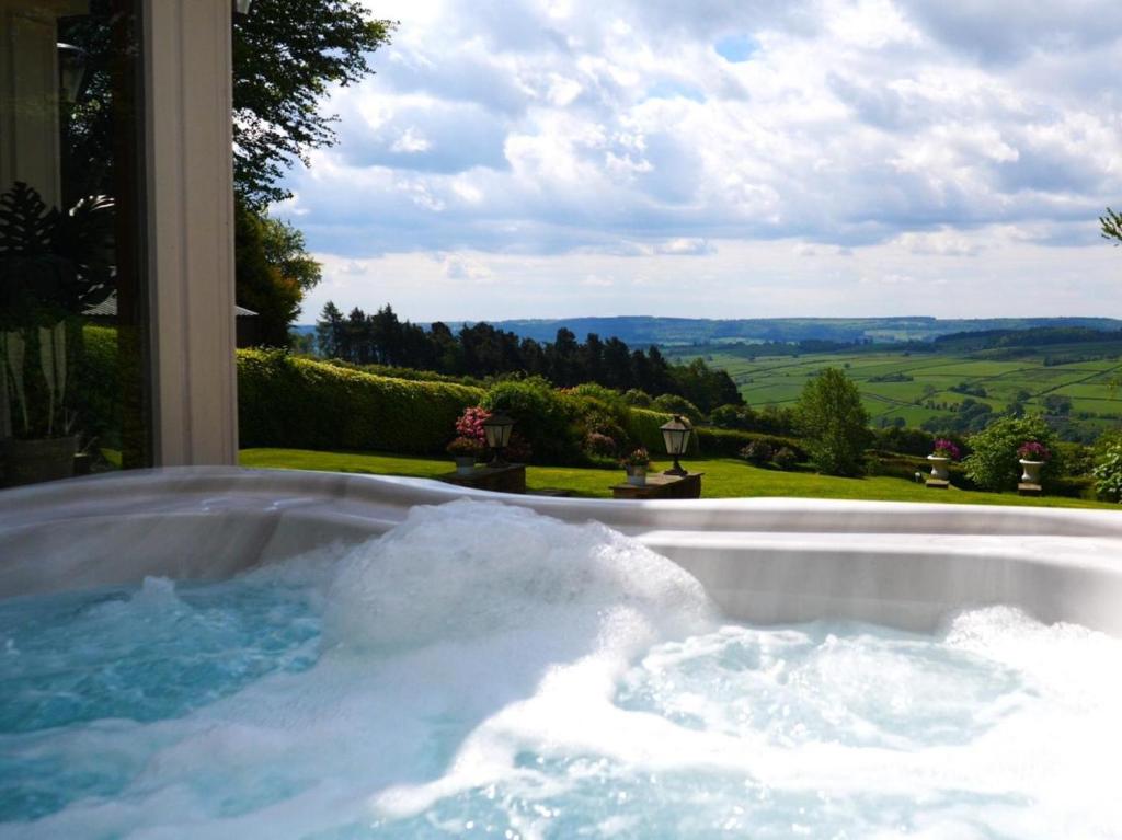 a jacuzzi tub with a view of the countryside at 6 Bed in Otley oc-g0022 in Fewston