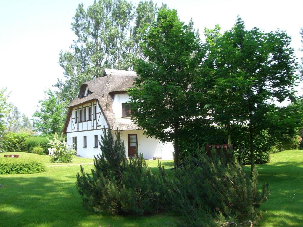 a large white house with a thatched roof at Boje Haus Sanddorn in Althagen