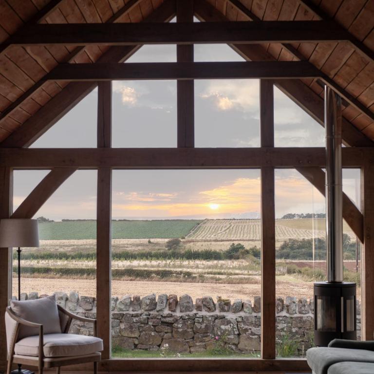 a room with a large window looking out at a field at Hoolet's View, East Lothian in Whittingehame
