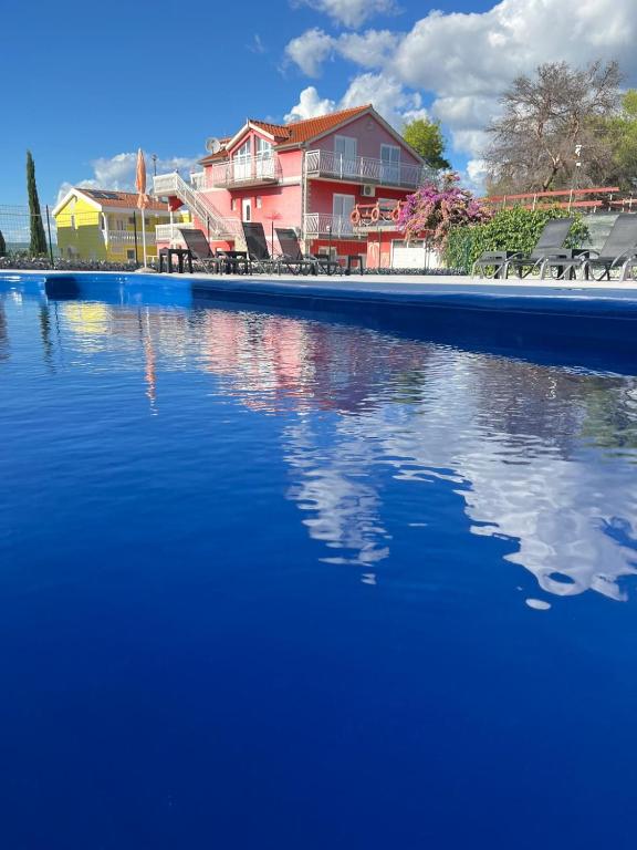 a pool of water with a house in the background at Lipovac resort Ficus in Bilice