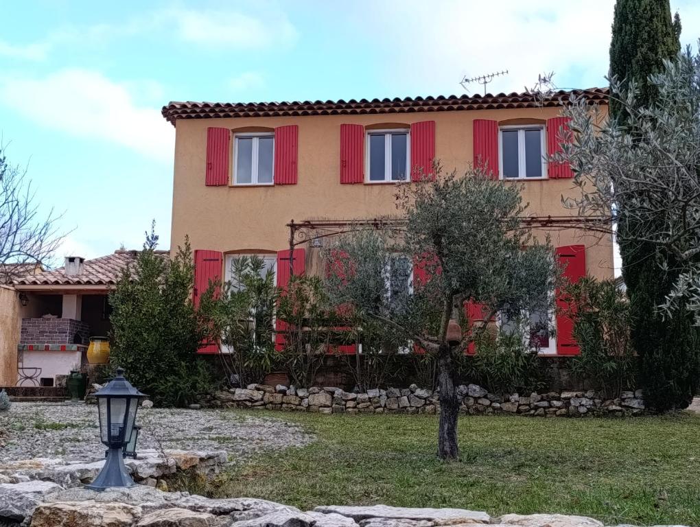 a house with red shutters and a street light at La bastide 4 chambres in Artignosc-sur-Verdon