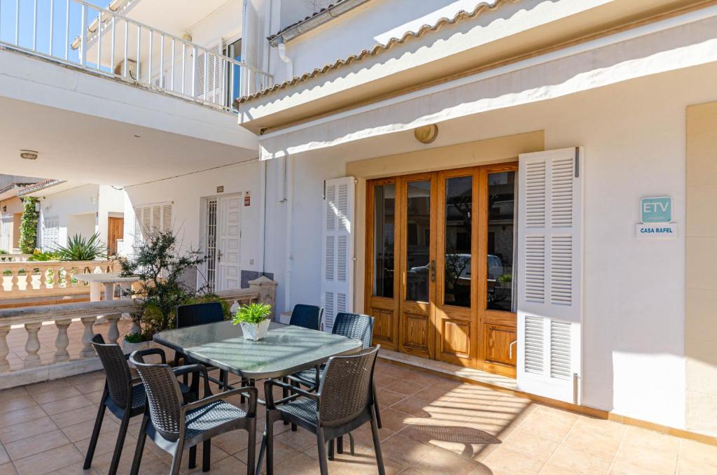 a patio with a table and chairs in front of a house at YourHouse Casa Rafael in Can Picafort