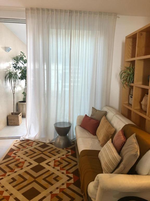 a living room with a couch in front of a window at Maré do Bairro Studio Beira Mar Aveiro in Aveiro