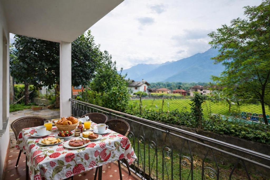 a table with a plate of food on a balcony at Casa Curti 1 in Sorico