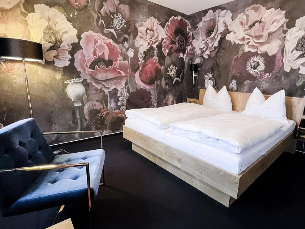 a bedroom with a bed and a floral wall at DORMERO Hotel Crailsheim in Crailsheim