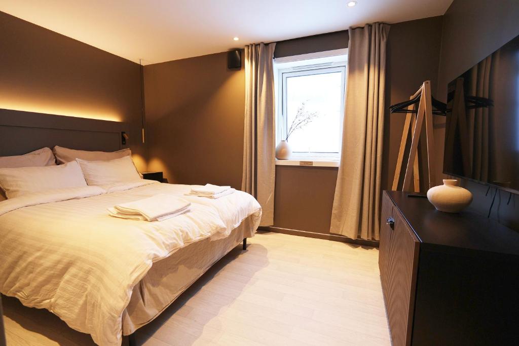 a bedroom with a large bed and a window at Arctic City Suites 2 in Kirkenes