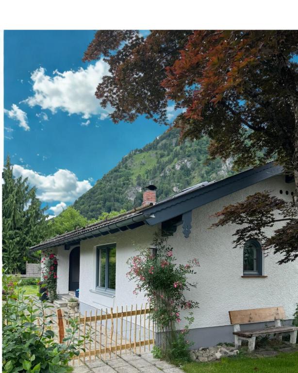 a white house with a mountain in the background at Chiemgau One in Marquartstein