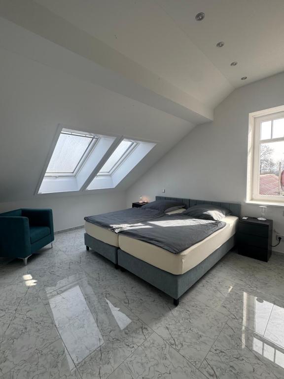 a bedroom with a bed and a window and a chair at Gestüt Kaiserhof in Legelshurst