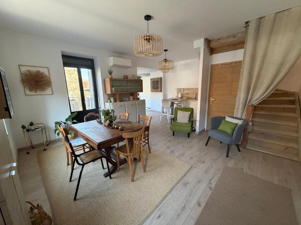 a dining room and living room with a table and chairs at L'Etape des Jacquets - Monistrol d'allier in Monistrol-dʼAllier