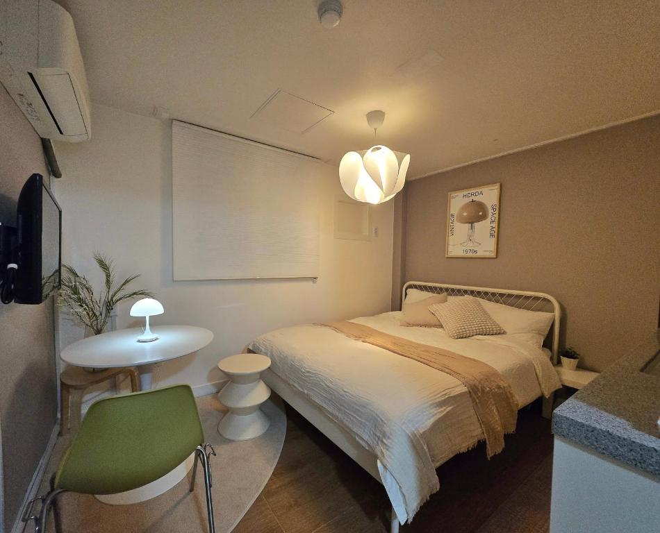 a small bedroom with a bed and a table at The YoGwan in Suwon