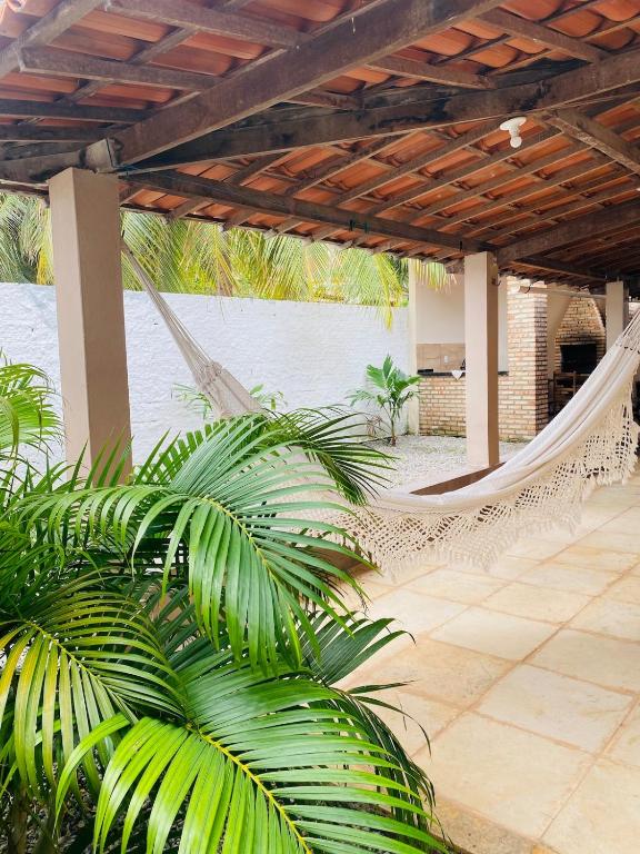 a hammock in a resort with a patio at Casa em Praia de Flecheiras in Trairi