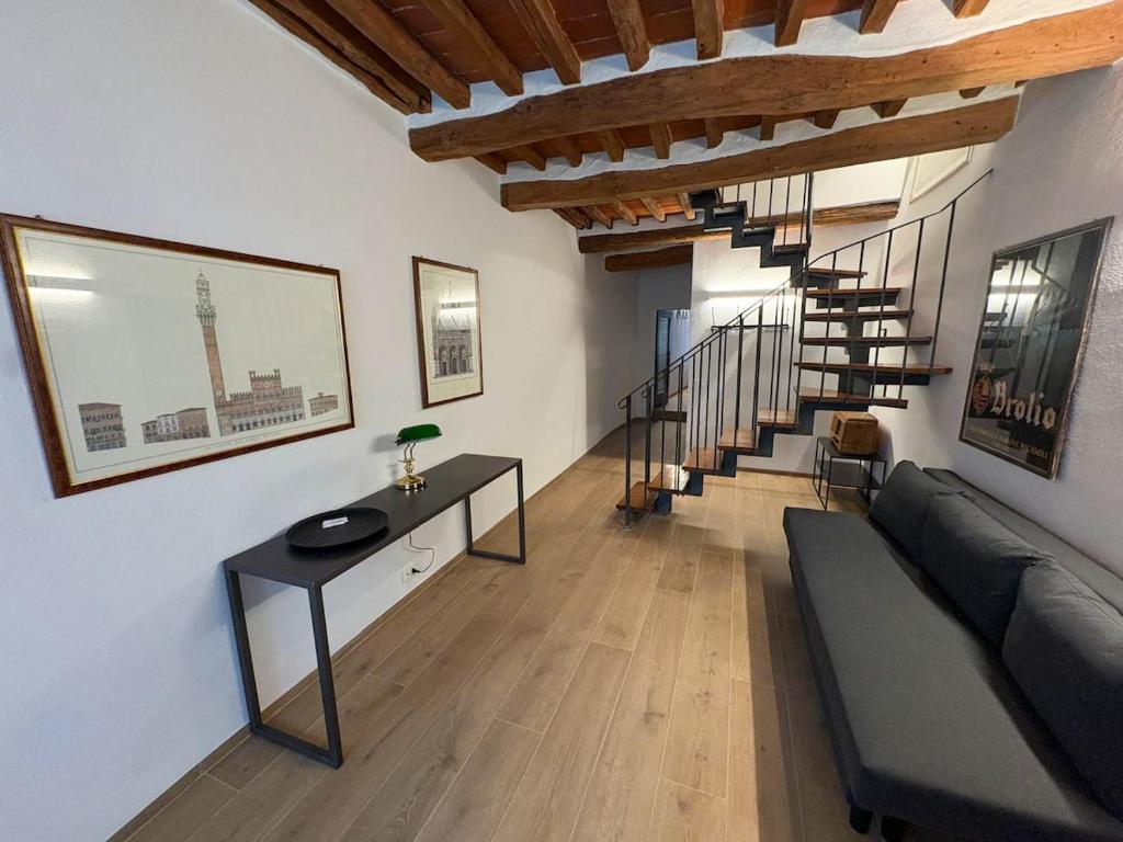 a living room with a couch and a staircase at Tuscany Charme Apartments in Asciano