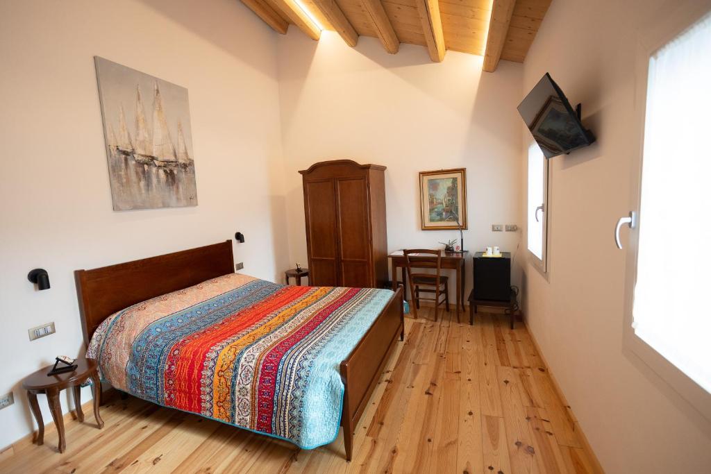 a bedroom with a bed and a table in a room at B&B Basta Bussare in Chioggia