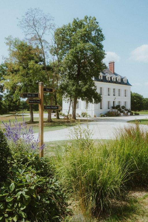a street sign in front of a white house at Domaine Du Roncemay - Hôtel, Restaurants, Spa & Golf in Aillant-sur-Tholon