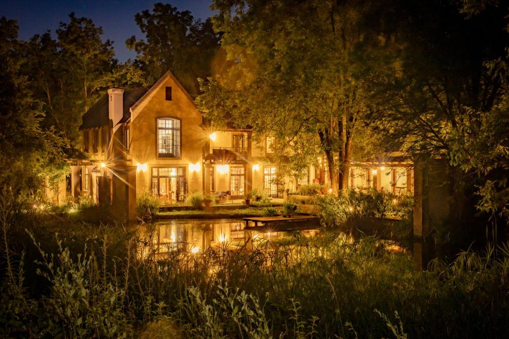 a house with lights in the yard at night at The River Villa in Magaliesburg