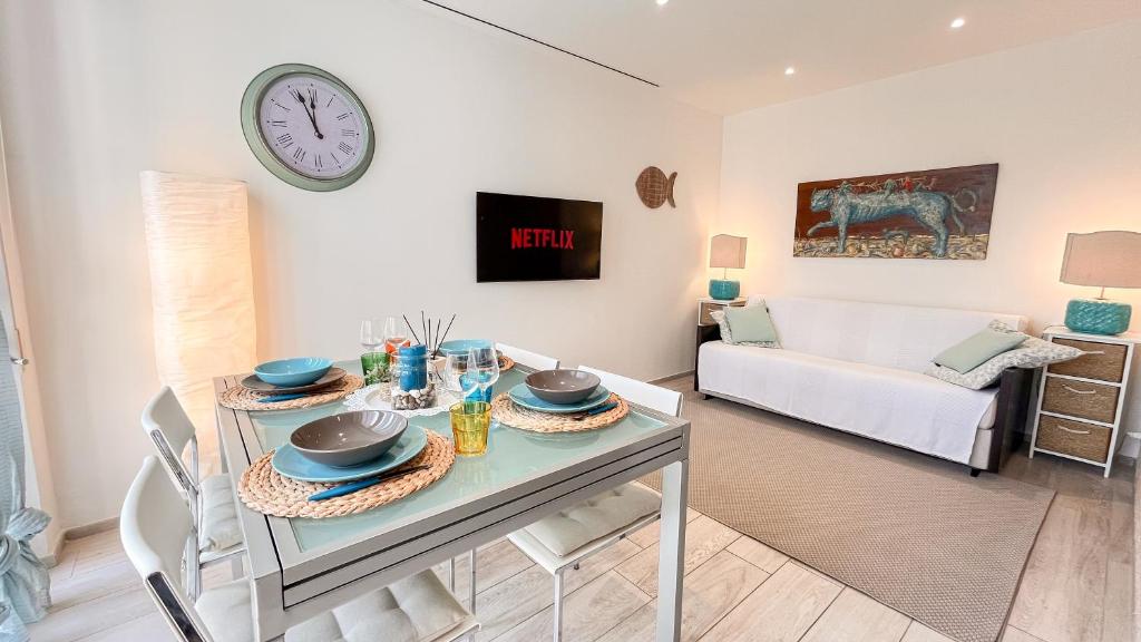 a living room with a table and a clock on the wall at Casa Elisabeth in Portovenere