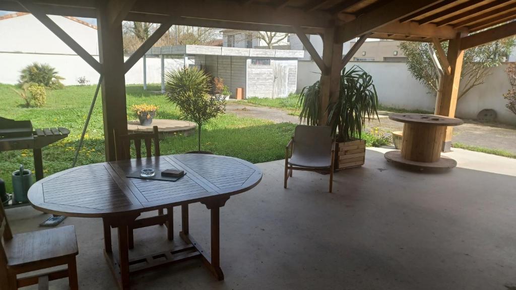 a patio with a table and a chair at Les Deux Chambres Aucamville in Aucamville