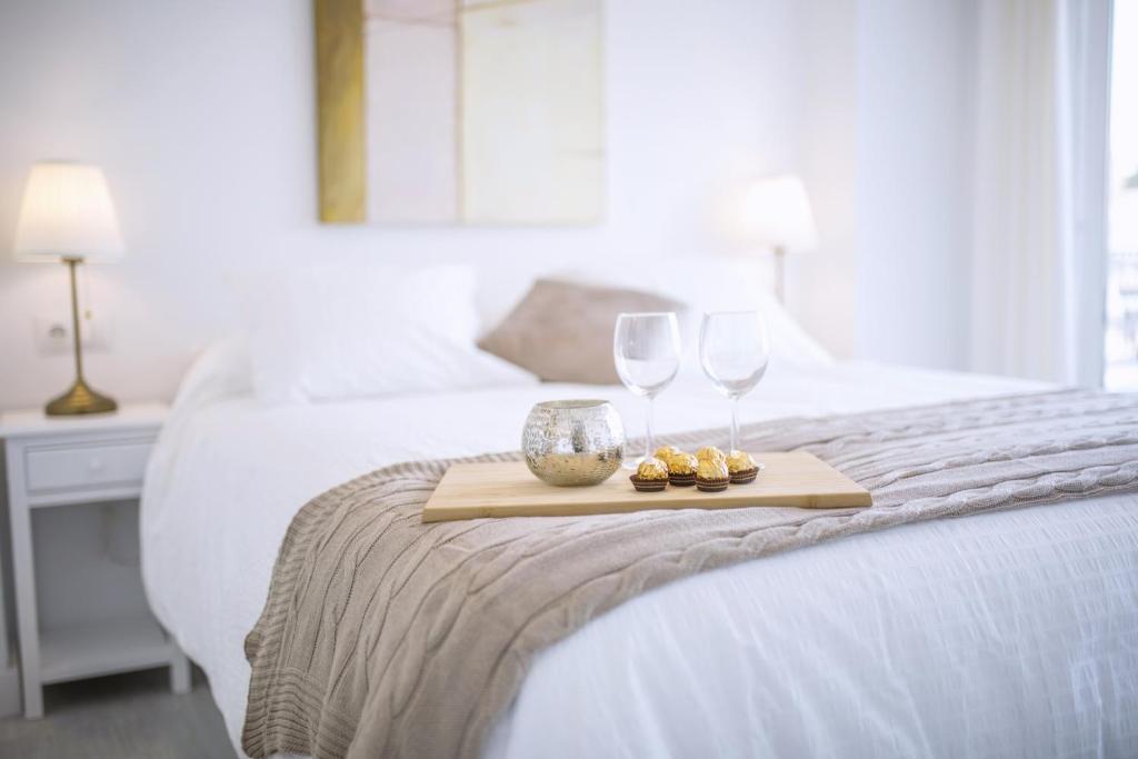 bandeja con 2 copas de vino y galletas en una cama en Casa Picasso 6, en Málaga