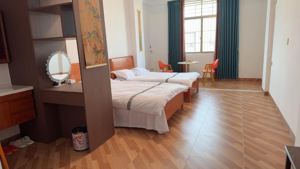 a hotel room with two beds and a mirror at 道和轩民宿 in Heyuan