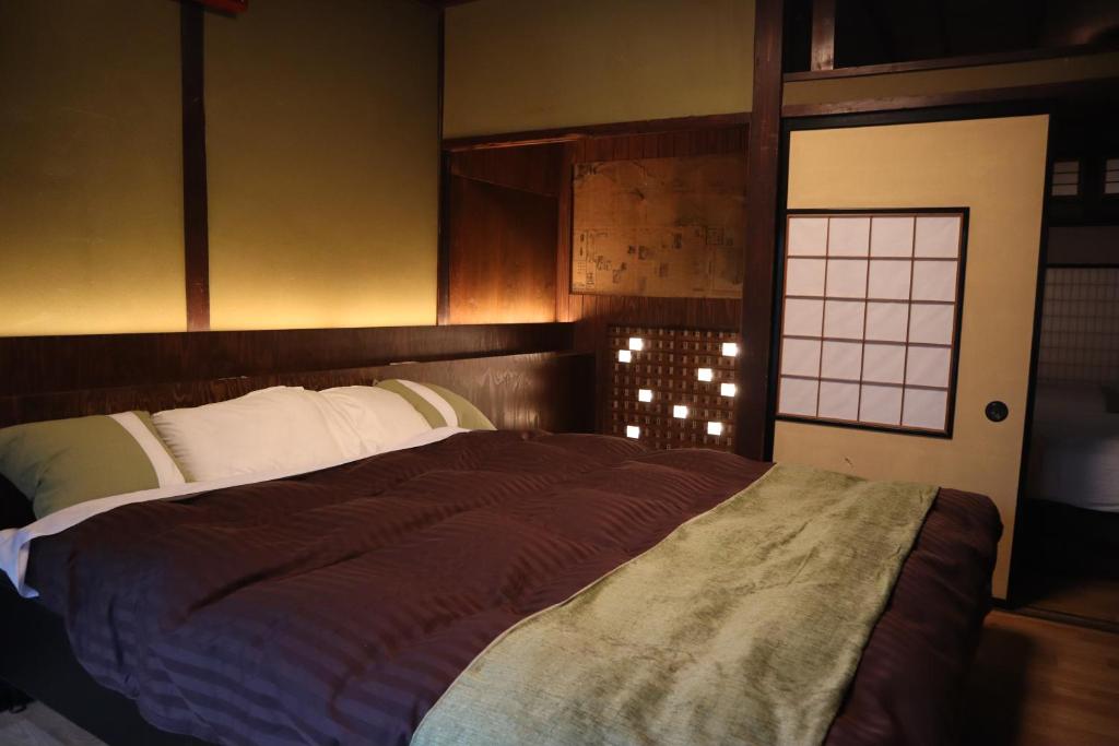a bedroom with a large bed and a window at Baiyaku-yadoya Yamaki #HH4 in Toyama
