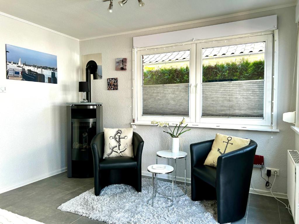 a living room with two chairs and a window at Haus Seeblick Ferienhaus Priwall in Priwall