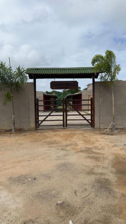 a bus stop with a gate and two palm trees at Rancho Helena in Maceió