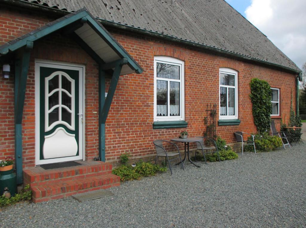a brick house with a table and chairs outside at FeWo 2 - Haus Lorenzen in Hörsten