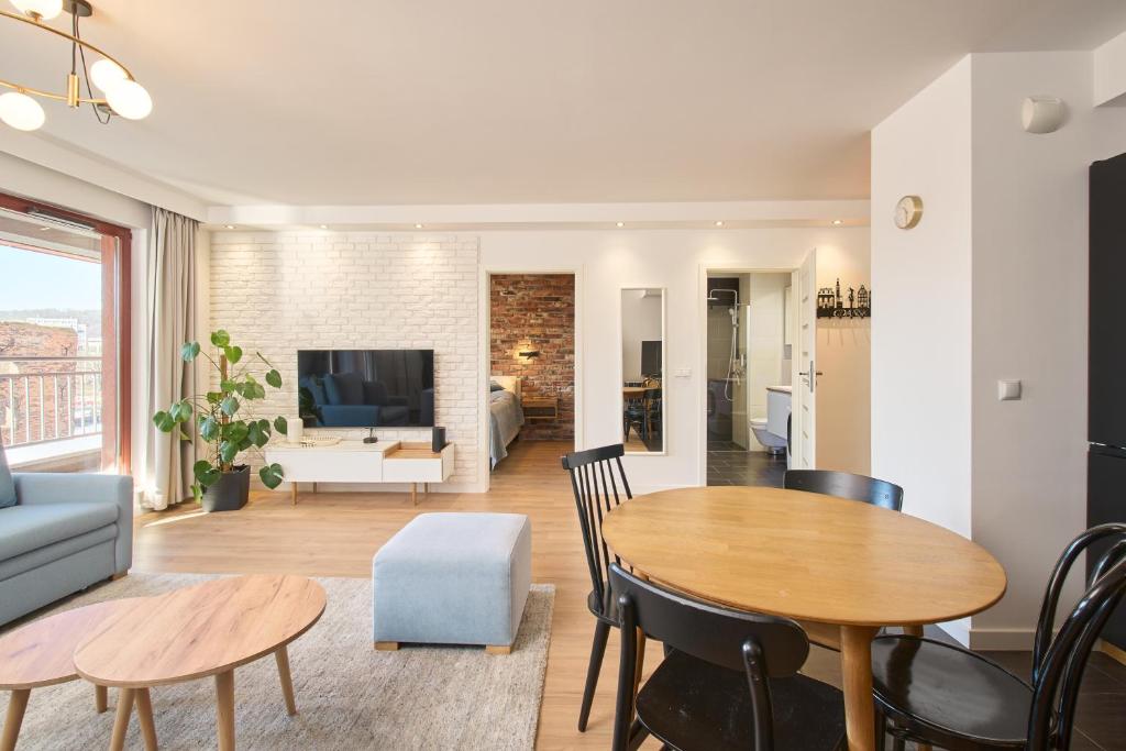 a living room with a table and chairs and a couch at Nord-A Waterlane Island SPA in Gdańsk