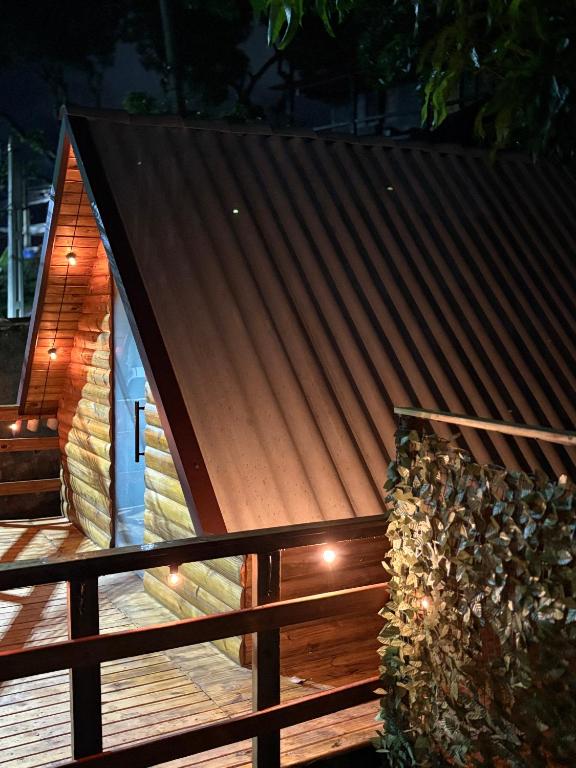a small cabin with a brown roof and a wooden fence at A Cabana Caiçara in Ilhabela