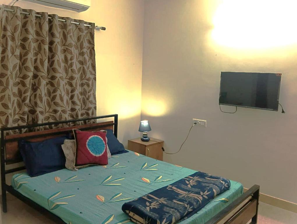 a bedroom with a bed with a flat screen tv at Comfort Zone in Chennai