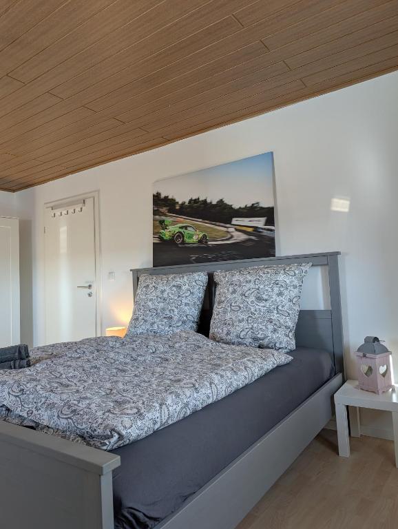 a bedroom with a bed with a poster on the wall at Drive & Dream Nürburgring in Drees