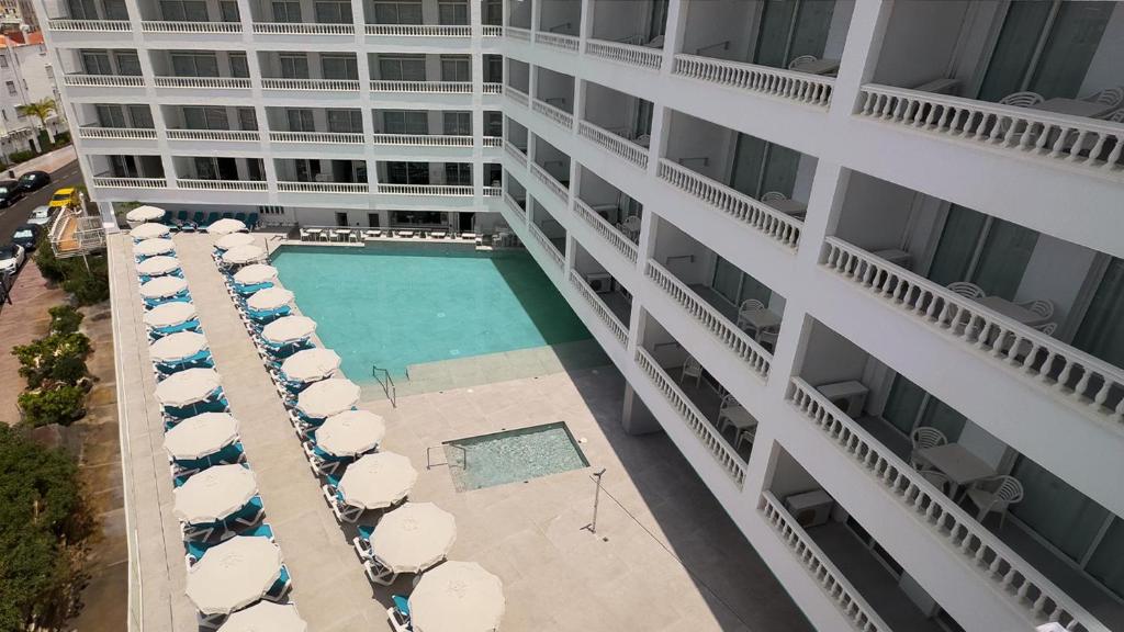 an aerial view of a building with a swimming pool and umbrellas at BLUESEA Lagos de Cesar in Puerto de Santiago