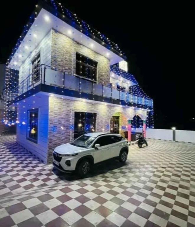 a car parked in front of a house with lights at Sariyal Homestay in Kandikhal