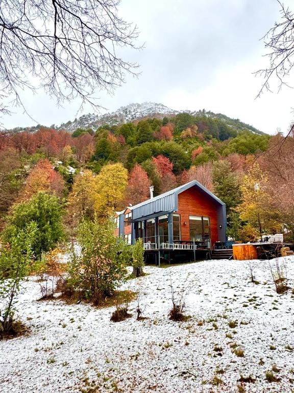 a house sitting on top of a snow covered field at Refugio entre Montañas - Malalcahuello in Malalcahuello