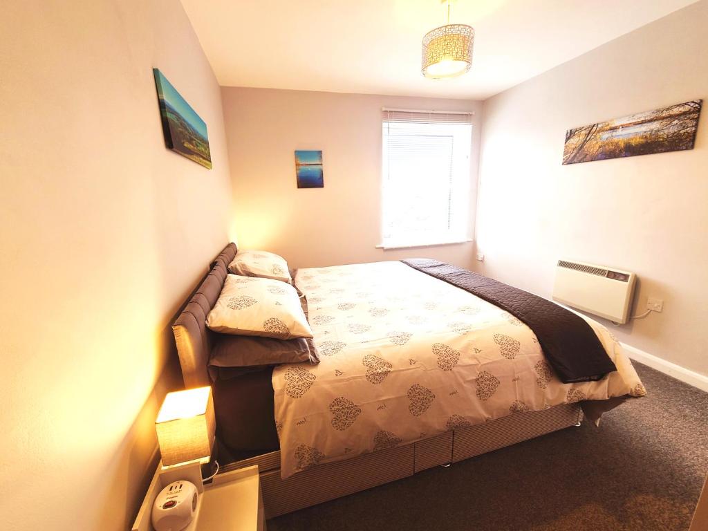 a bedroom with a bed and a window at Parkside Apartment Normanton in Wakefield