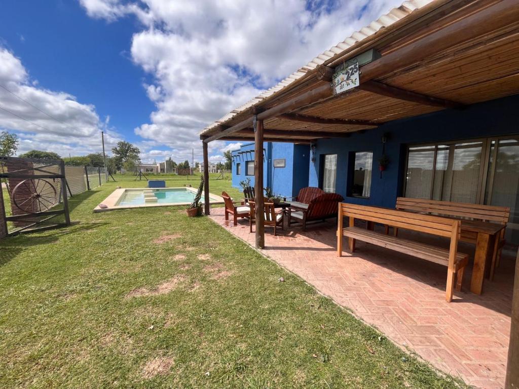 a blue house with a bench and a pool at Casa Azul Roldan in Roldán
