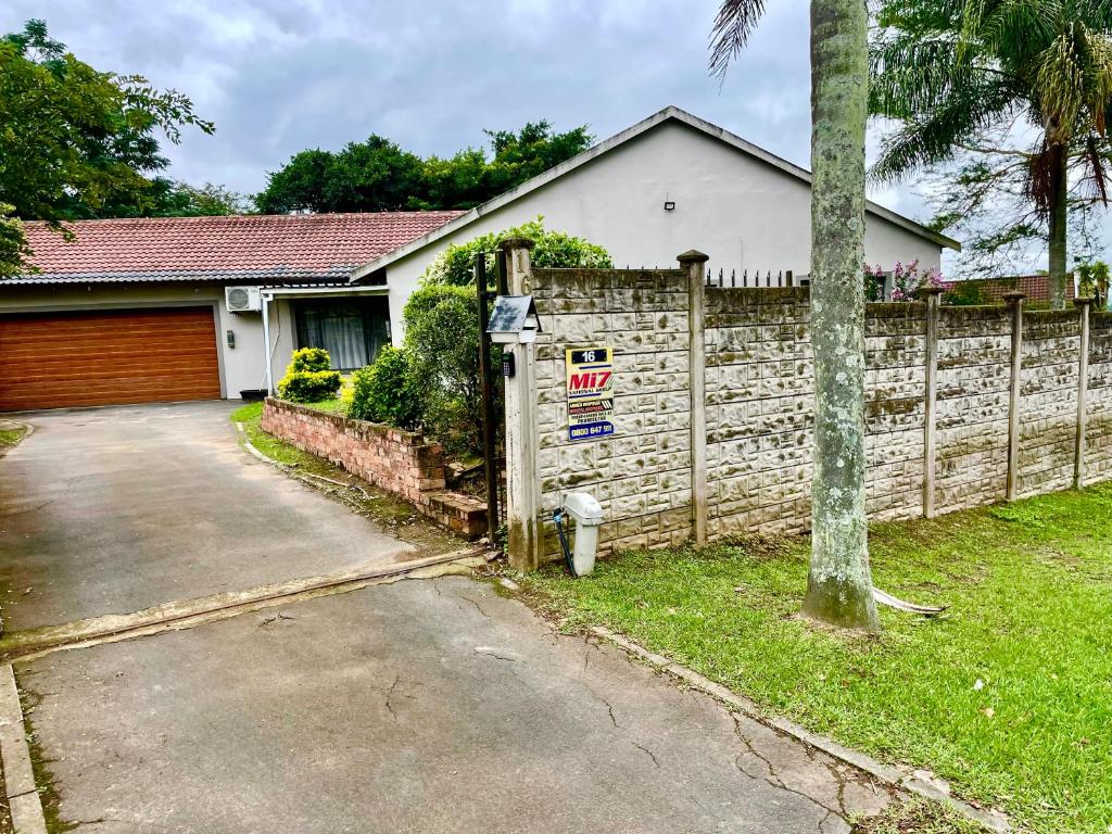 a house with a wooden fence and a driveway at 16 on Les De Jager in Pietermaritzburg