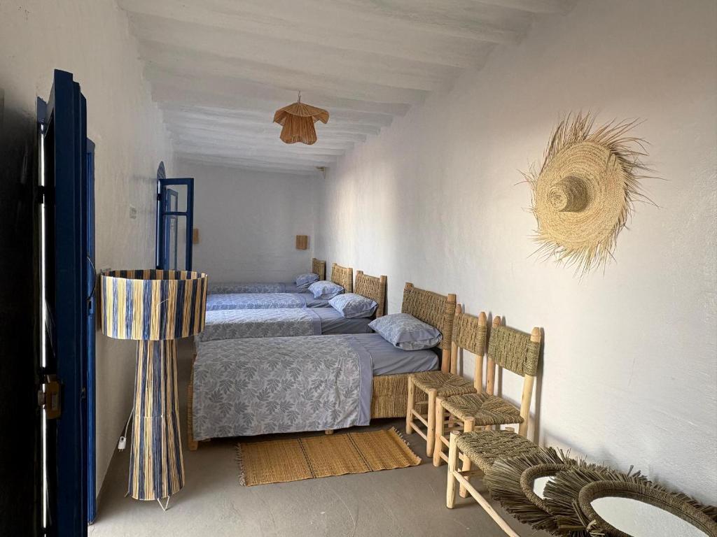 a bedroom with two beds and two chairs in it at Darnamed in Nador