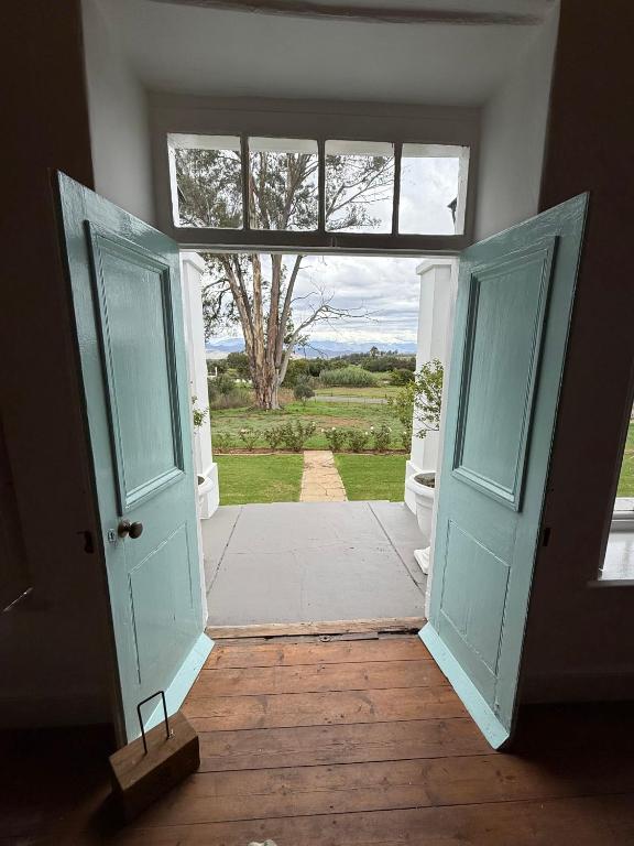 an open door to a room with a tree in the background at Firgrove Country House in Robertson