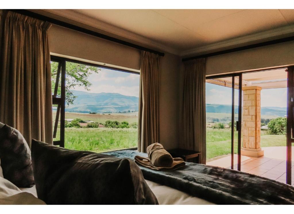 a room with a couch and a large window at Aloe Corner, Cathkin Estates by Euphoric Leisure in Ardmore