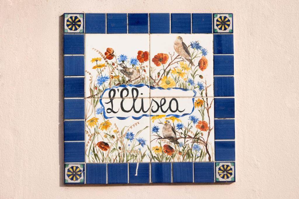 a tile mosaic of flowers and birds on a wall at L'Elisea Maison De Charme in Castellabate